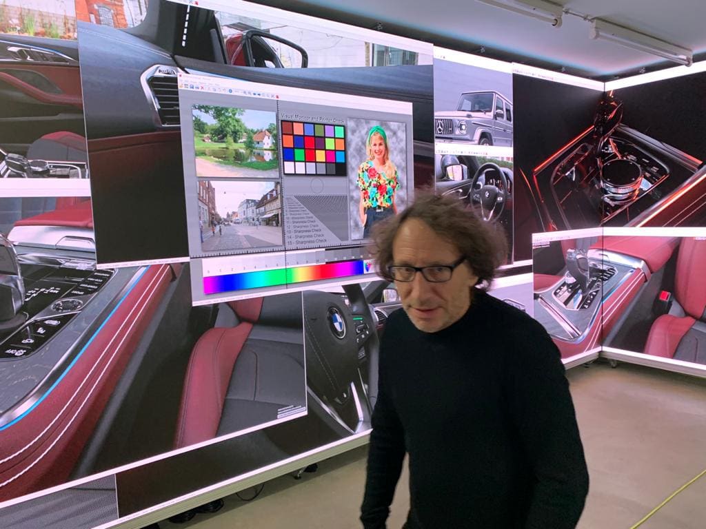 Automotive design studio with curved TRUE dvLED walls showing car interiors beside a color reference chart
