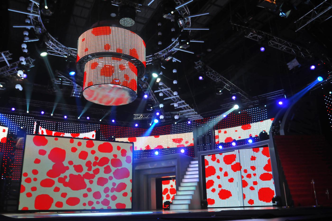 Suspended TRUE dvLED drum above a staircase set with red poppy graphics on white dvLED walls