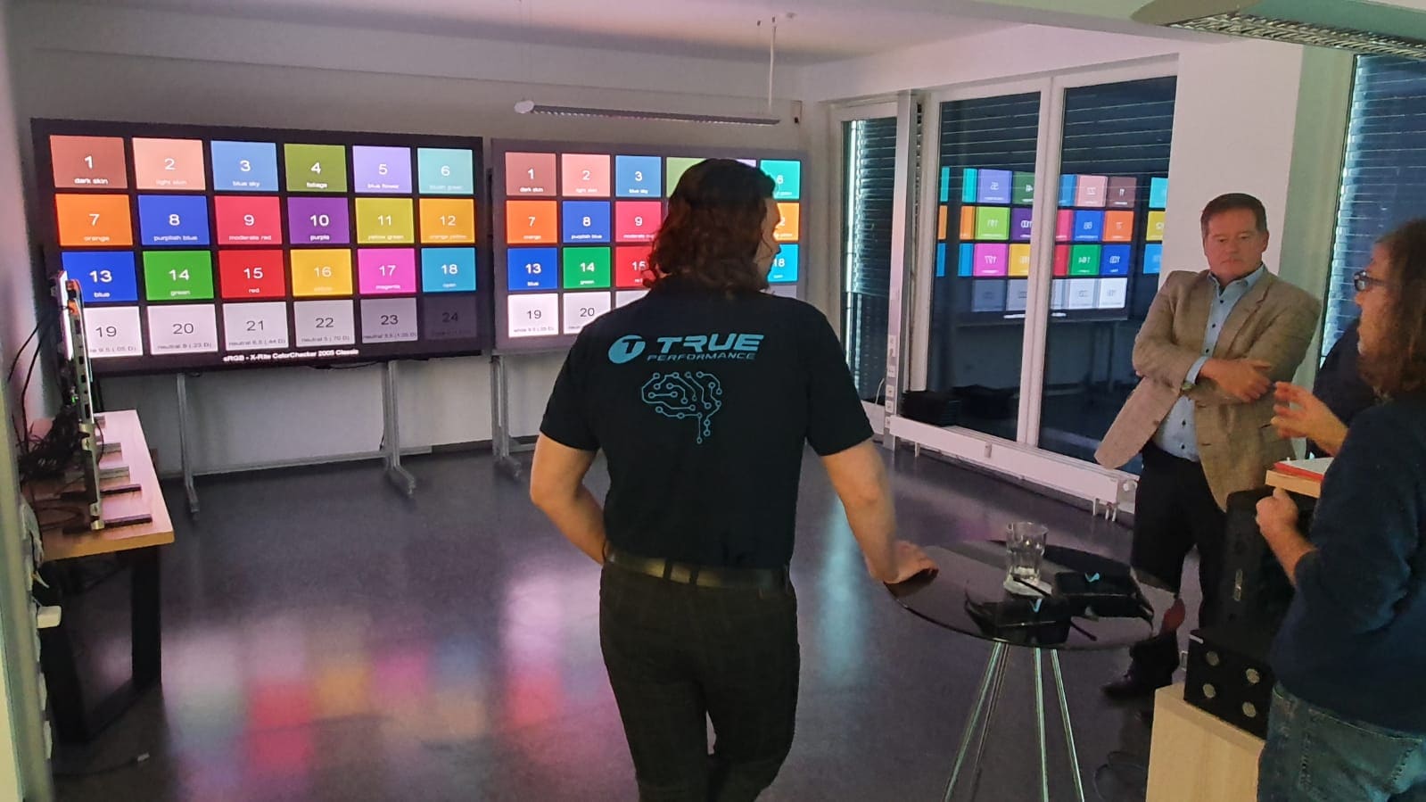 TRUE engineer in front of two dvLED walls showing color reference charts during a customer measurement