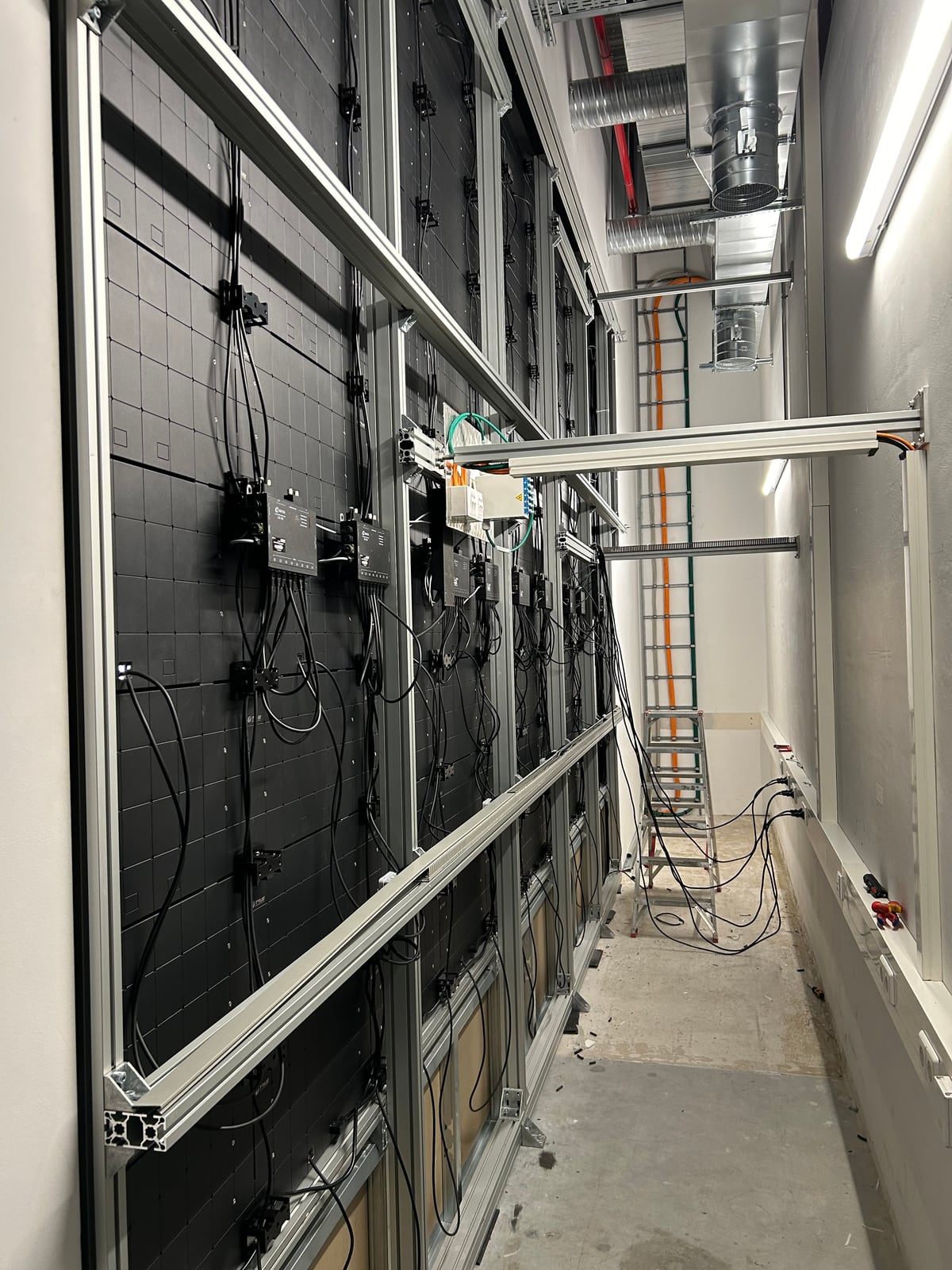 Rear of a TRUE dvLED wall during installation: aluminium substructure, receiving cards and data cabling before the panels are closed