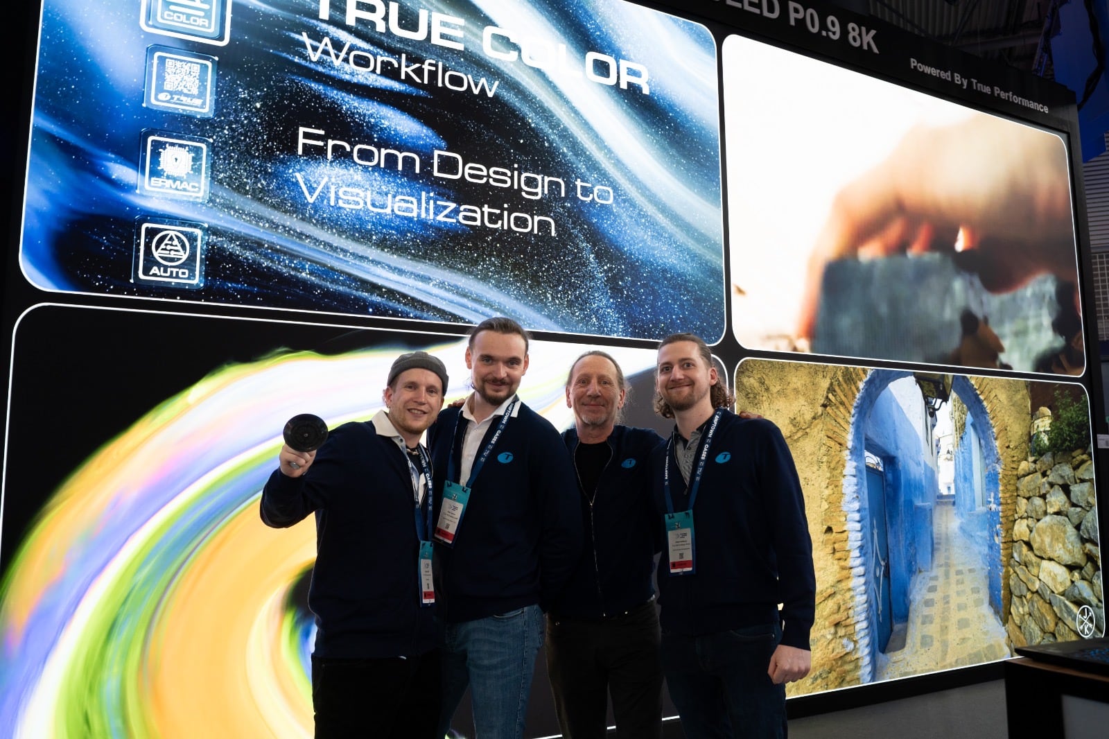 Four TRUE Performance team members in front of the TRUE Color Workflow dvLED wall on the TRUE trade show stand